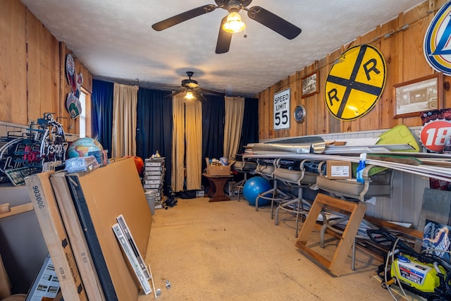 miscellaneous room featuring a textured ceiling and wooden walls