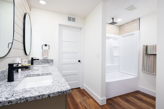 bathroom featuring visible vents, a sink, and wood finished floors