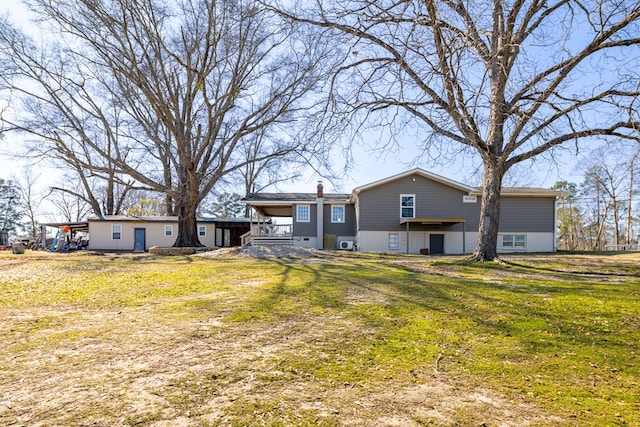 rear view of house featuring a yard and a chimney