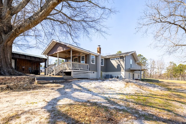 view of front of house with a chimney and central air condition unit