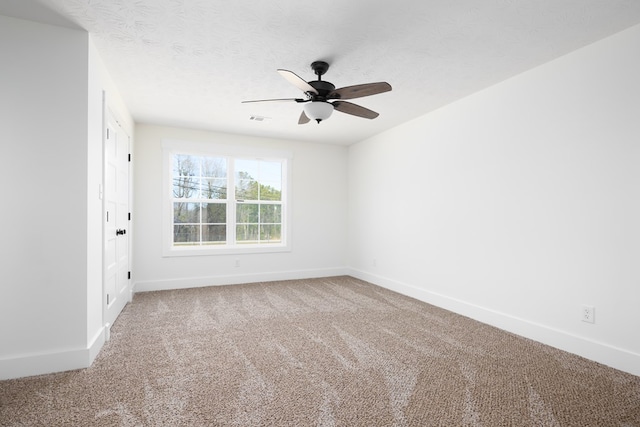 empty room featuring a textured ceiling, carpet flooring, visible vents, and baseboards