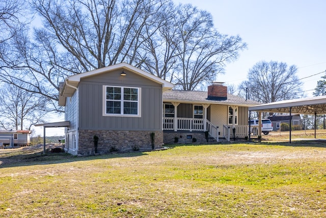 view of front of property with stone siding, a chimney, covered porch, a front lawn, and board and batten siding