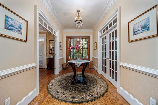 interior space featuring hardwood / wood-style flooring, a notable chandelier, crown molding, and french doors