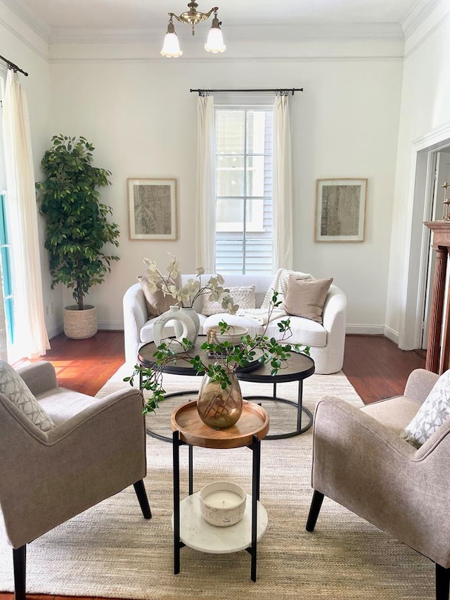 living room featuring hardwood / wood-style flooring, crown molding, and a notable chandelier