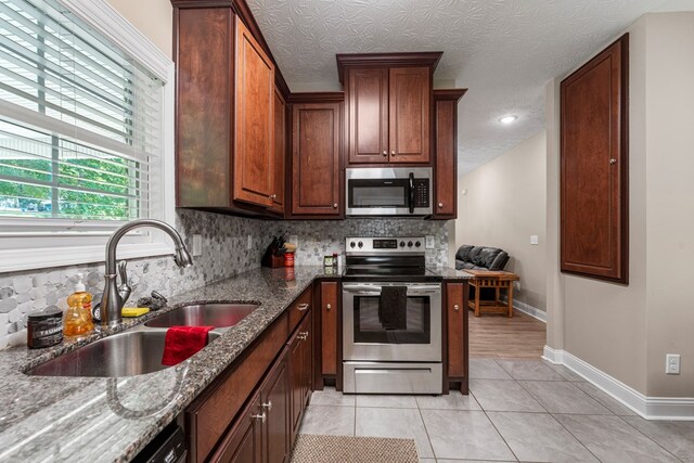 344 Lee Road 2040, Phenix City, AL 36870 - kitchen with stainless steel appliances, backsplash, dark stone countertops, and light tile patterned flooring