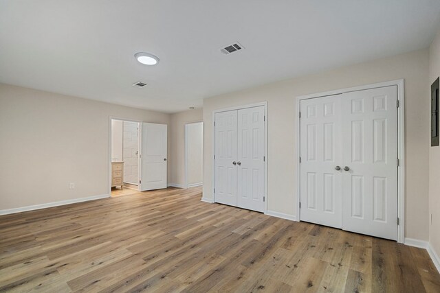 1474 Brewer Ave, Columbus, GA 31903 - unfurnished bedroom featuring connected bathroom, light hardwood / wood-style floors, and multiple closets