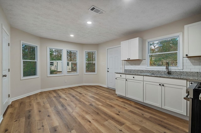 1474 Brewer Ave, Columbus, GA 31903 - kitchen featuring sink, white cabinetry, stainless steel range, light stone countertops, and decorative backsplash