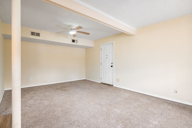 empty room with visible vents, beamed ceiling, ceiling fan, and carpet floors