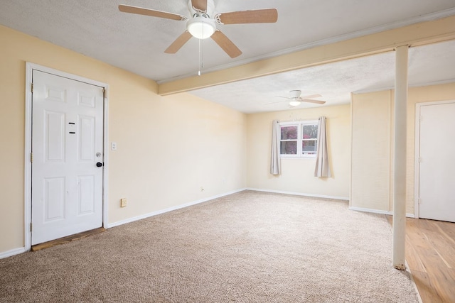 carpeted empty room featuring baseboards, a textured ceiling, and ceiling fan