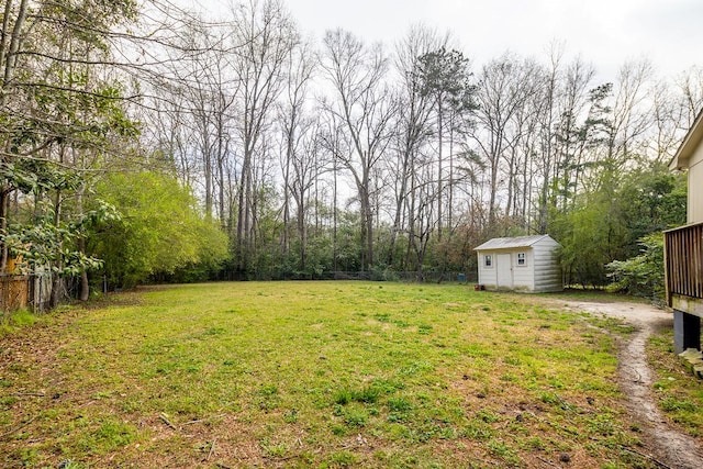 view of yard with a storage unit, an outbuilding, and fence