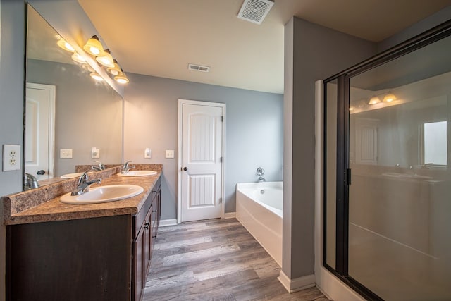 bathroom featuring wood-type flooring, vanity, and separate shower and tub