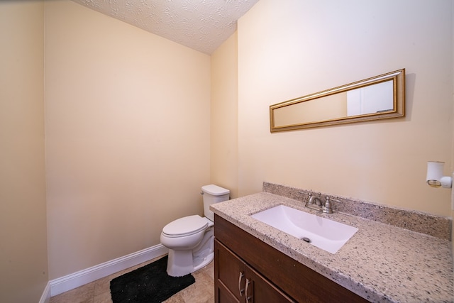 bathroom with vanity, tile patterned floors, a textured ceiling, and toilet