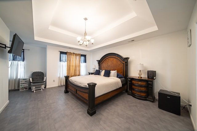 bedroom with a raised ceiling and a chandelier