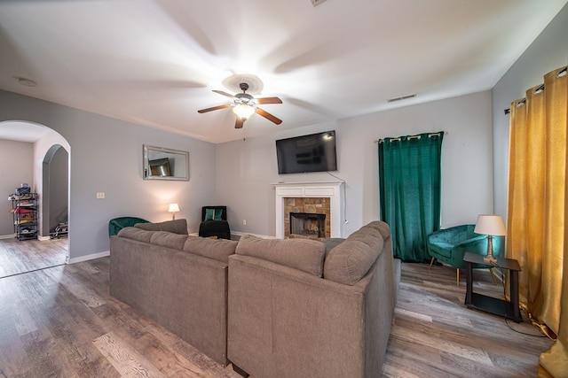 living room with a tile fireplace, ceiling fan, and hardwood / wood-style flooring