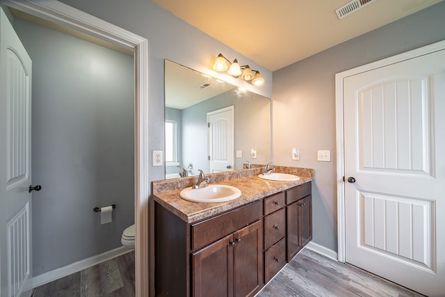 bathroom featuring vanity, toilet, and wood-type flooring