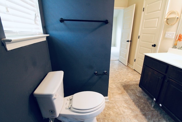 bathroom with vanity, toilet, and baseboards