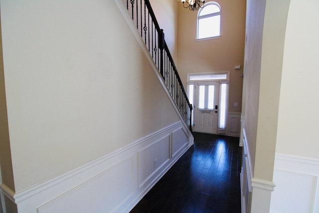 foyer featuring a wealth of natural light, stairway, and an inviting chandelier