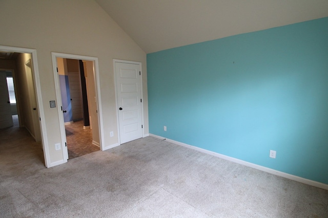 unfurnished bedroom with baseboards, lofted ceiling, and carpet flooring