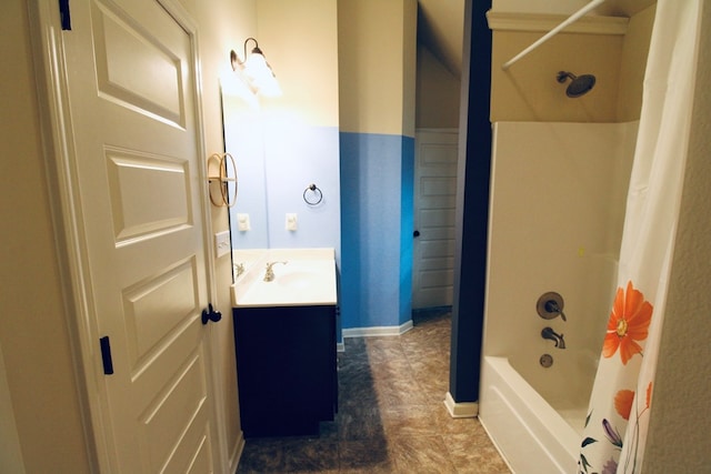 bathroom featuring vanity, baseboards, and shower / bath combo with shower curtain