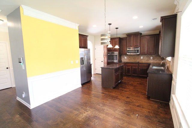 kitchen featuring a sink, appliances with stainless steel finishes, dark wood-style floors, and a center island