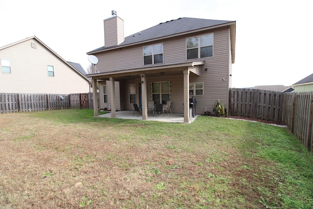 rear view of house featuring a yard, a patio, a fenced backyard, and a chimney