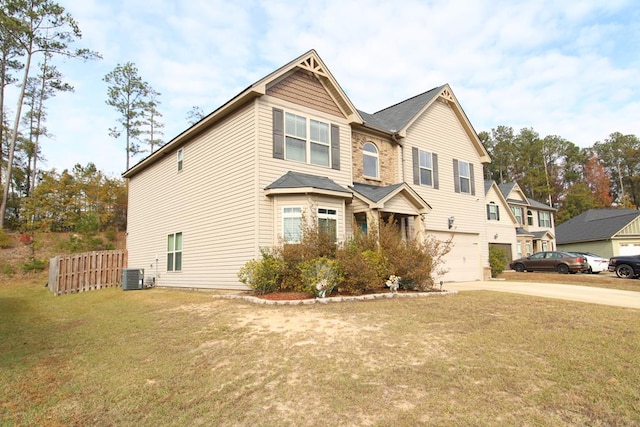 view of front of property with a front lawn, fence, concrete driveway, central AC, and an attached garage