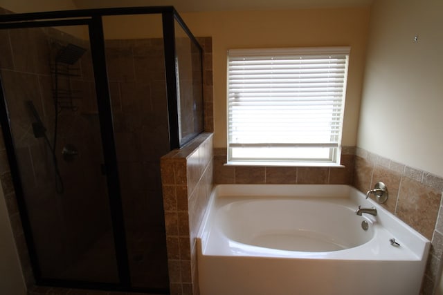 full bathroom with a garden tub and a shower stall