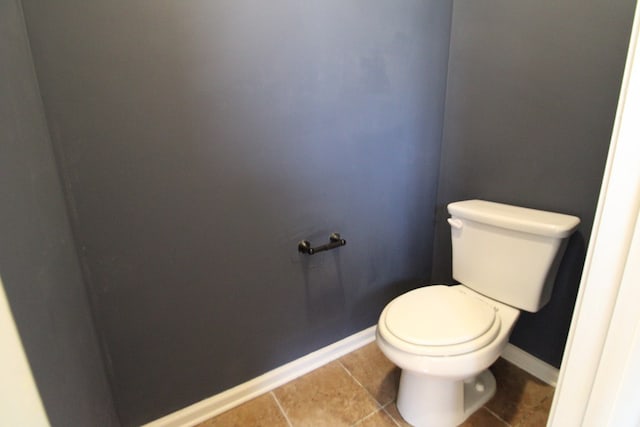 bathroom with tile patterned flooring, toilet, and baseboards