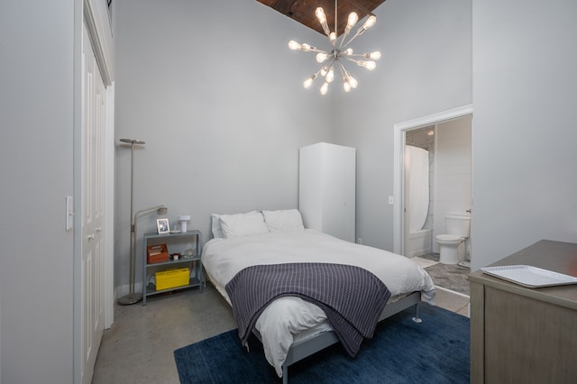 1201 Front Ave Unit 419, Columbus, GA 31901 - bedroom with a chandelier, a towering ceiling, concrete flooring, and ensuite bathroom