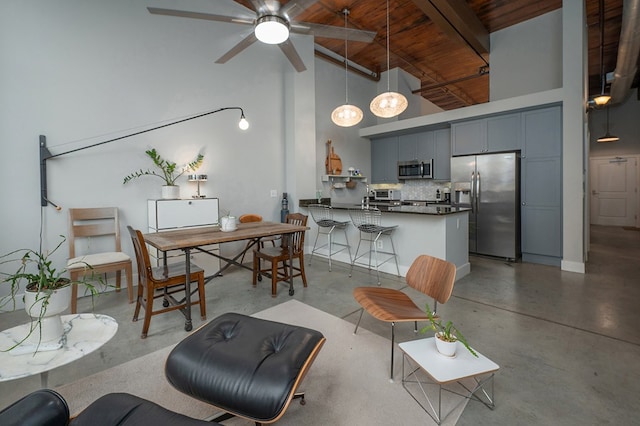 1201 Front Ave Unit 419, Columbus, GA 31901 - living room featuring finished concrete floors, wood ceiling with exposed beams, high vaulted ceiling, and ceiling fan