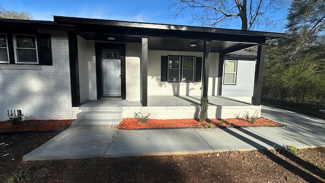 view of exterior entry with covered porch