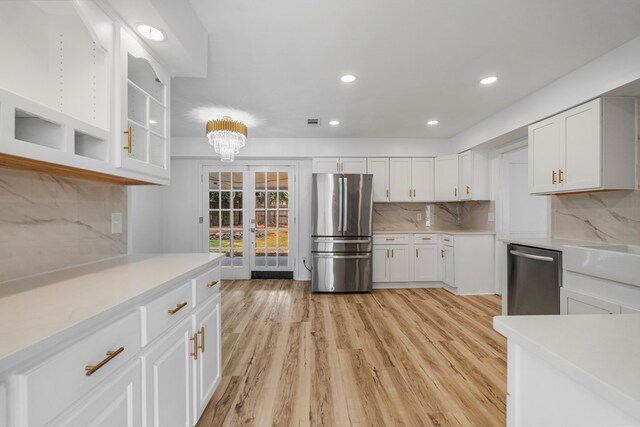 4975 Glacier Dr, Columbus, GA 31907 - kitchen with stainless steel appliances, light countertops, tasteful backsplash, white cabinets, and french doors