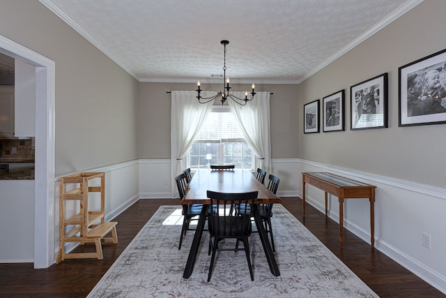 dining area with a textured ceiling, a chandelier, and ornamental molding