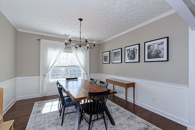 dining area with a textured ceiling, dark hardwood / wood-style floors, ornamental molding, and an inviting chandelier