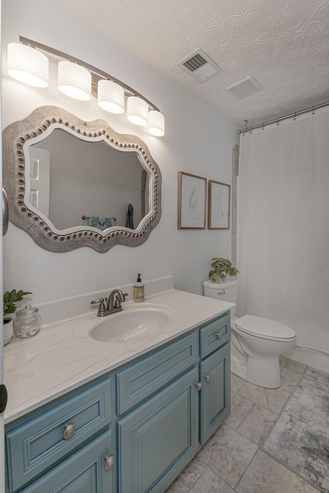 bathroom featuring a textured ceiling, toilet, vanity, and curtained shower