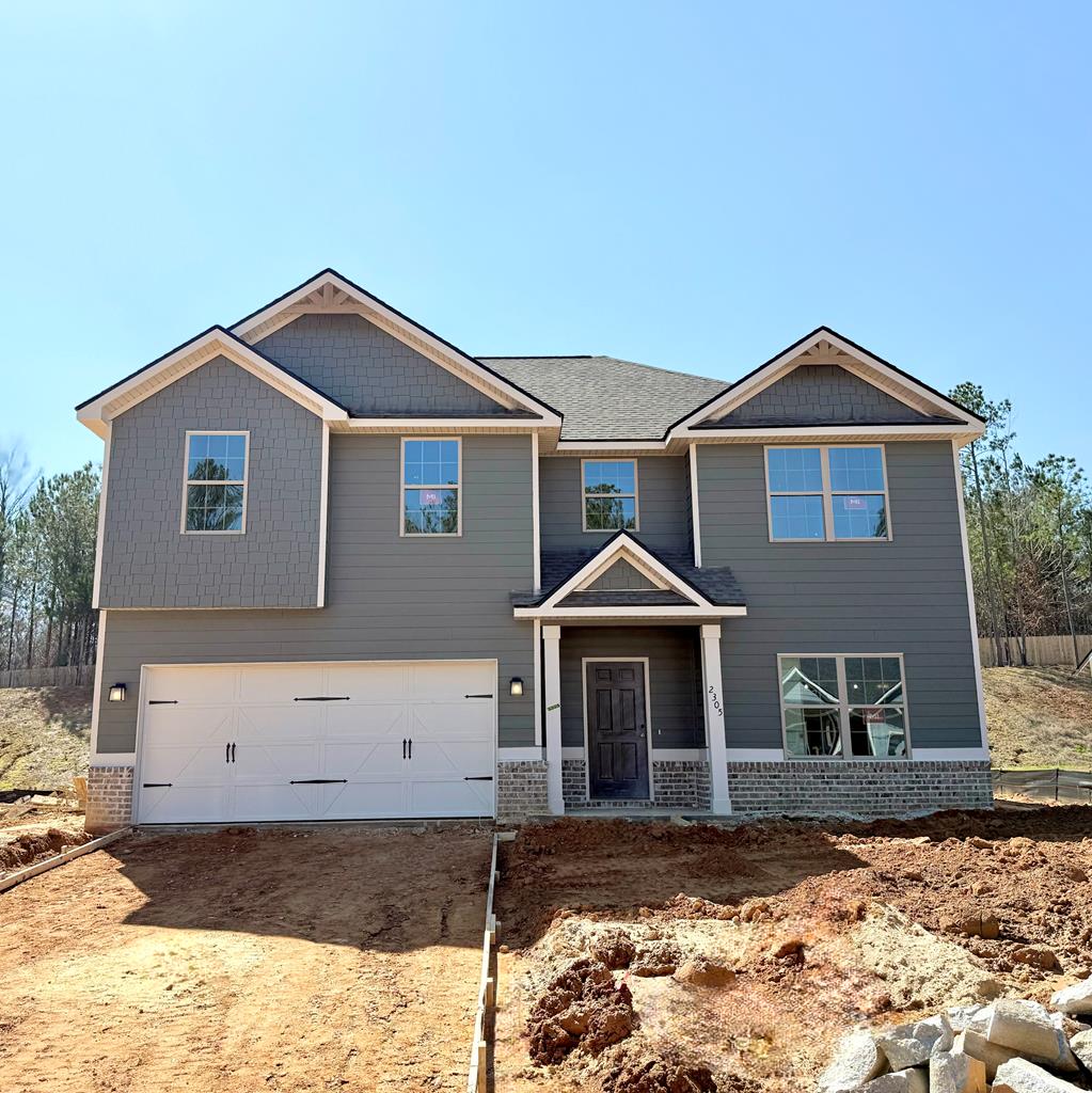 craftsman-style home featuring brick siding, driveway, and a garage