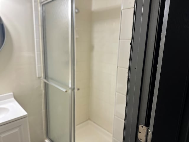 full bath with vanity and a shower stall
