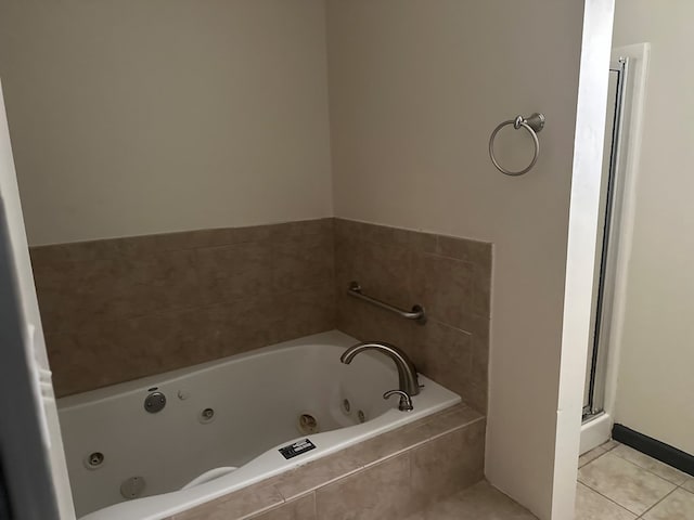 bathroom with tile patterned floors and a tub with jets