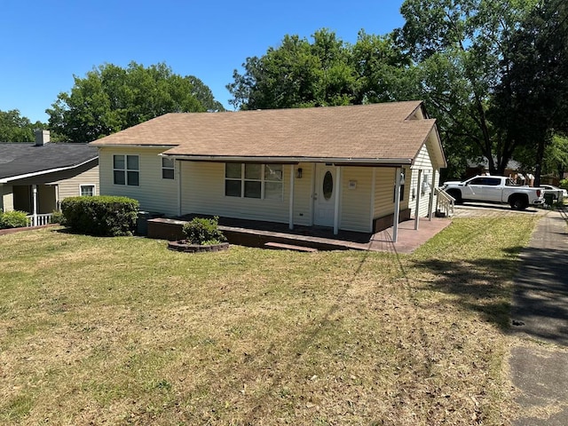 view of front facade with a shingled roof, a front lawn, and covered porch