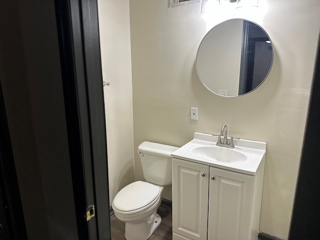 half bath featuring vanity, toilet, and wood finished floors