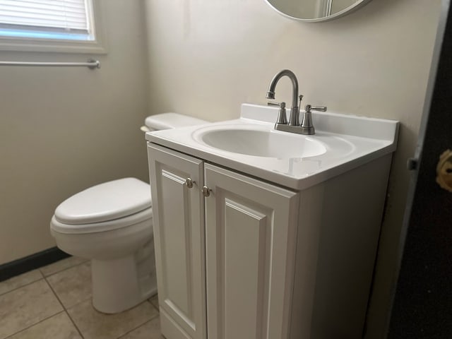 half bathroom with tile patterned flooring, toilet, and vanity