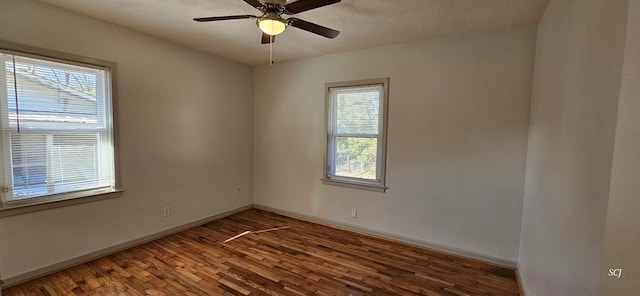 unfurnished room with ceiling fan, a wealth of natural light, and dark hardwood / wood-style flooring