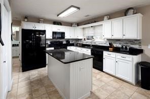 kitchen with light tile patterned flooring, black appliances, white cabinetry, dark countertops, and a center island