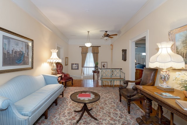 living room with hardwood / wood-style floors, ceiling fan, and crown molding