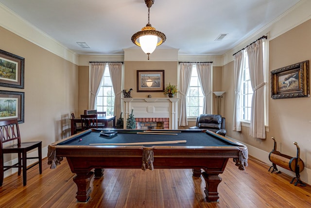 playroom with a brick fireplace, crown molding, hardwood / wood-style floors, and pool table