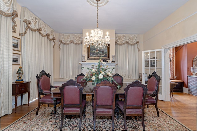 dining area featuring hardwood / wood-style flooring and an inviting chandelier