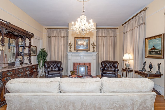 living room featuring a brick fireplace, wood-type flooring, and a chandelier