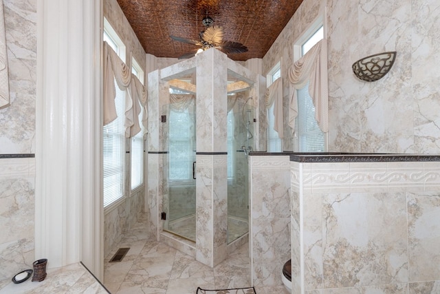 bathroom with ceiling fan, an enclosed shower, and brick ceiling