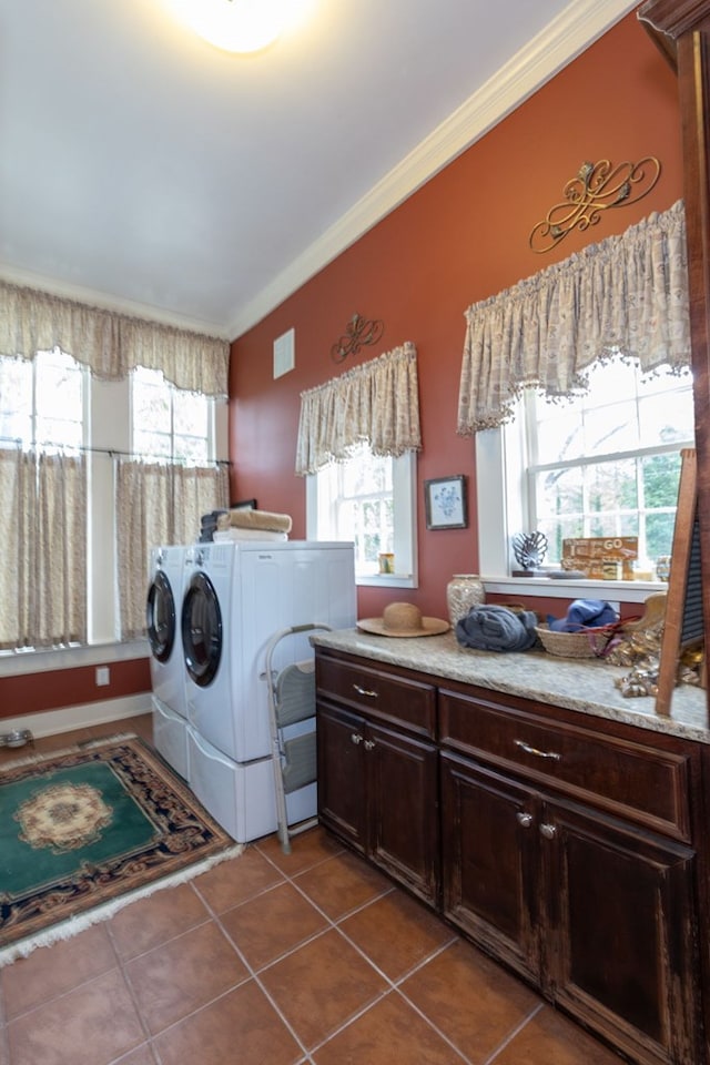 washroom with crown molding, washer and clothes dryer, and light tile patterned flooring