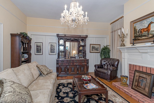 living room with light wood-type flooring, a fireplace, and a chandelier